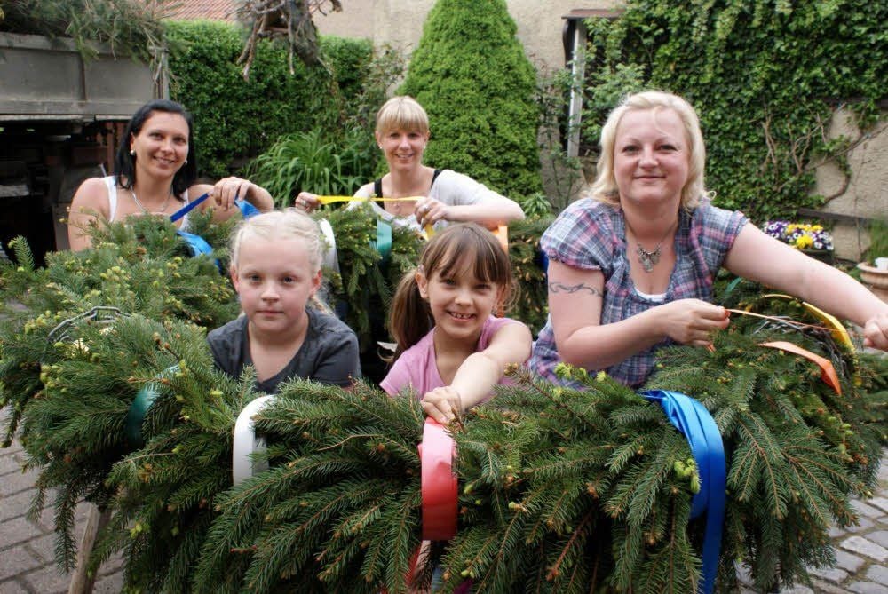 Hand in Hand wurde aus unzählig vielen Tannenzweigen der Kranz gebunden. Die Mädchen Annika Claußen und Melissa Pukallus binden mit Susanne Pukallus (hinten links), Kathleen Scheidig und Silvia Claußner den Kranz.