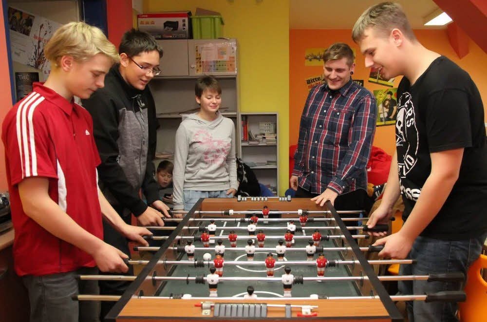 Schüler stehen in der Thomas-Müntzer-Schule in Sangerhausen um einen Kickertisch.