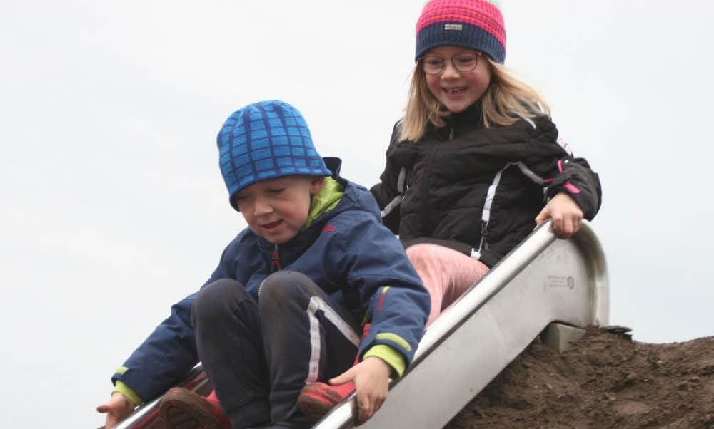 Die beiden Edelstahl-Rutschen über dem Tunnel-Labyrinth des Lindaer Mehrgenerationen-Spielplatzes haben es Anna und Max Uthe sofort angetan.