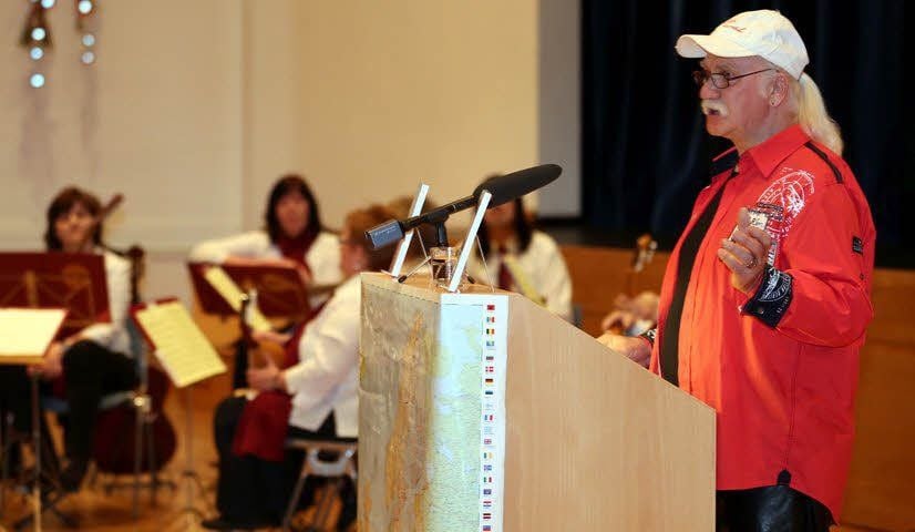 Dieter Christian Ochs stellt sein Buch in Hohenmölsen vor, im Hintergrund lauschen auch Musiker des Mandolinenorchesters.