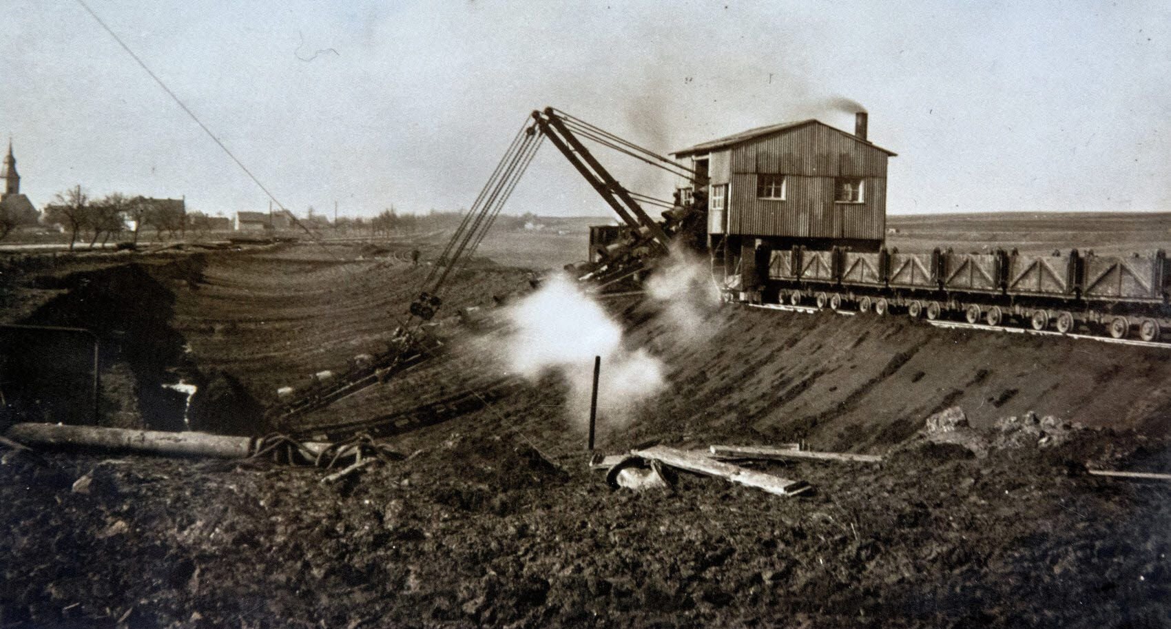 Die Anfänge: 1907 begann dieser Dampfbagger mit dem Kohleabbau in der Grube „Elisabeth“. Im Hintergrund sieht man den Müchelner Ortsteil Stöbnitz.