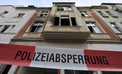 Ein Absperrband der Polizei hängt in Duisburg vor einem Wohnhaus, in dem bei einem Brand vier Kinder ums Leben gekommen sind. (FOTO: DDP)