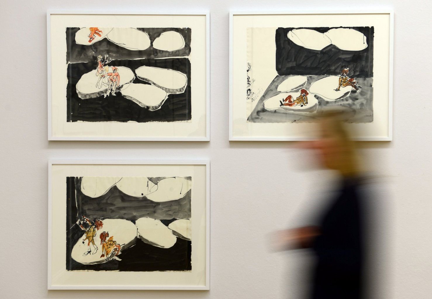 Eine Frau geht in den Kunstsammlungen Chemnitz (Sachsen) an Entwürfen des Malers Georg Baselitz vorüber. Baselitz hatte die Bilder im Rahmen seiner Arbeit für das Bühnenbild der Oper "Le Grand Macabre" geschaffen.