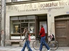 Passanten gehen in der Salomonstraße im ostsächsischen Görlitz an einer im Stil der 1950-er Jahre umgestalteten Hausfassade mit dem Schaufenster einer aus dieser Zeit stammenden Waagenfabrik vorbei. Seit Beginn dieser Woche ist ein 120-köpfiges Filmteam in der Stadt, um Szenen für den Hollywood-Streifen «Der Vorleser» nach Bernhard Schlinks gleichnamigem Bestseller zu drehen. (Foto: dpa)