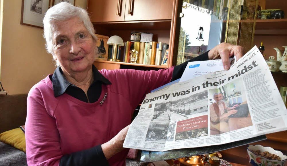 Ein Chronist beschäftigt sich in Dorchester mit der Geschichte des Lagers, in dem Maren Hoffmanns Großvater Kriegsgefangener war. Sie zeigt eine aktuelle Zeitungsausgabe, die ihr frühere Gastgeber aus Südengland jetzt geschickt haben. Mit ihnen steht die 81-Jährige noch immer in Kontakt.