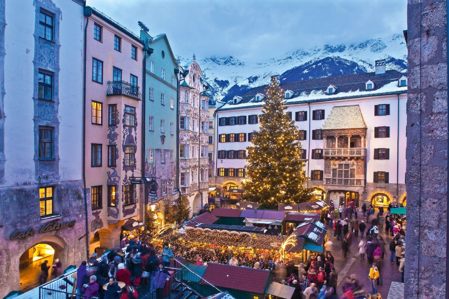 Glühwein, Pfeffernüsse – und manchmal sogar Bergblick: So schön können Weihnachtsmärkte in den Alpen sein. Besucht man den traditionellen Weihnachtsmarkt in Innsbruck, kann man das Adventstreiben von einer Aussichtplattform über den Hüttendächern betrachten.