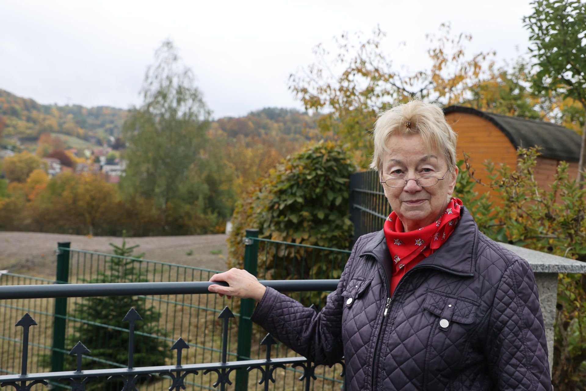 Thüringen, Schmalkalden: Ute Schütze, unmittelbare Anwohnerin, steht am Zaun der ehemaligen Erdrutschstelle am Röthberg.