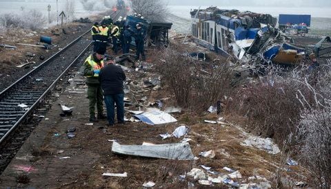 Bundespolizisten und Feuerwehrleute stehen am Sonntag in Hordorf bei Oschersleben nach dem Zusammenstoß eines privaten Harz-Elbe-Expresses (HEX) mit einem Güterzug am Samstag am völlig zerstörten Waggon der Regionalbahn. (FOTO: DAPD)