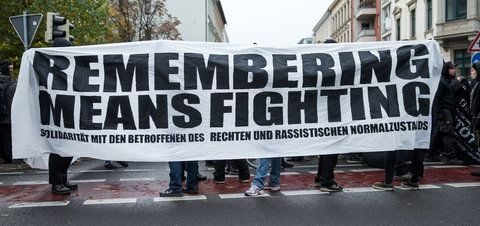 Demonstranten protestieren mit einem Transparent mit der Aufschrift «Remembering means fighting» in Leipzig in der Innenstadt. (FOTO: DPA)