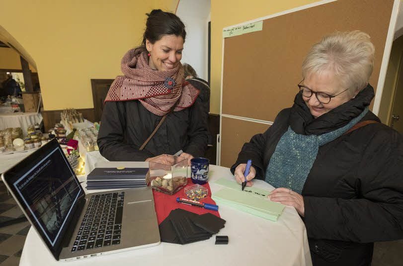 Nicole Müller (v.l.) vom Verein „heimatbewegen“ freut sich über Bärbel Hösel, die den ersten Wunsch für Ballenstedt an die Tafel heftete.