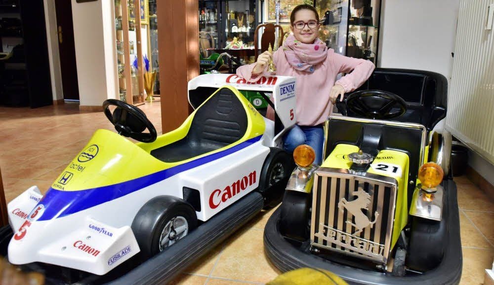 Enkelin Clara inmitten der Sammlung, zu der auch zwei Autoscooter vom Jahrmarkt gehören.