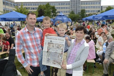 Besucher stehen mit einem Sonderdruck der MZ-Wochenendausgabe «Schön, dass Sie uns besucht haben» am Tag der offenen Tür auf dem Gelände der Mitteldeutschen Zeitung. (FOTO: THOMAS MEINICKE)