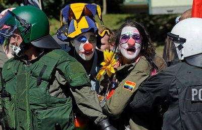 Als Clowns verkleidete Teilnehmer einer linken Gegendemonstration protestieren in Altenburg abgeschirmt durch Polizisten gegen das «Fest der Völker» der rechtsextremen NPD. (Foto: ddp)