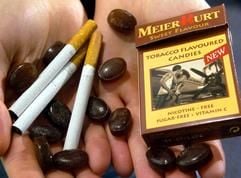 Messemodel Anne hält auf dem Gelände der koelnmesse in Köln Zigaretten und «Tabacco Flavoured Candies» in den Händen. Die nikotinfreien Bonbons mit Tabak-Geschmack sind als Alternative zu Zigaretten in Nichtraucher-Zonen gedacht. (Foto: dpa)