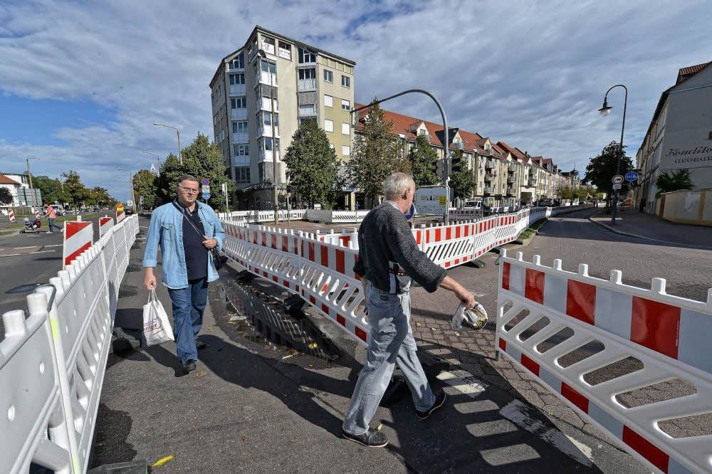 Fußgänger schlängeln sich durch das Absperr-Labyrinth, um zur Kurt-Weill.-Straße zu gelangen.