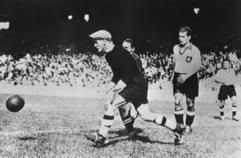 Der Wiener Torhüter Rudolf Raftl, der zusammen mit acht weiteren österreichischen Spielern zum «großdeutschen» WM-Aufgebot von 1938 gehört, klärt beim ersten Spiel gegen die Schweiz in Paris vor dem Schweizer Mittelstürmer Bickel (vorn rechts). (Foto: dpa)