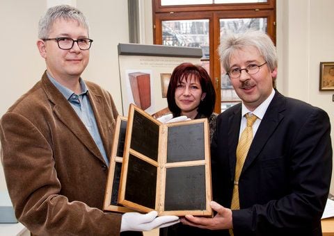 Christoph Roth (links), Leiter Buchrestaurierung Leipzig GmbH, Christiane von Nessen (Mitte),Teamleiterin Dokumentation des Archivs und Ralf Jacob, Leiter des Stadtarchivs zeigen das restaurierte Wachstafelbuch von 1656. (FOTO: SILVIO KISON)
