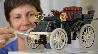 Museumsleiterin Evelies Baumann entstaubt im Museum Karrasburg im saechsischen Coswig das Modell im Massstab 1:8,5 des Autos Coswiga Tonneau. (FOTO: DDP)