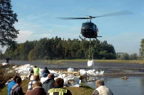 Im 30-Sekunden-Takt fliegen Hubschrauber der Bundeswehr an den Deichdurchbruch, um so genannte "Big Bags" zentimetergenau an den Stellen abzusetzen, den die Helfer am Boden vorbereitet haben. (Foto: Achim Kuhn)