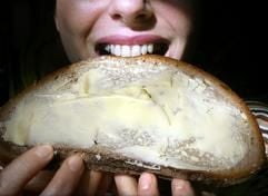 Genüßlich beißt eine junge Frau in Berlin in eine dick bestrichenes Butterbrot. Der 28.09.2007 ist der «Tag des Deutschen Butterbrotes». (Foto: dpa)