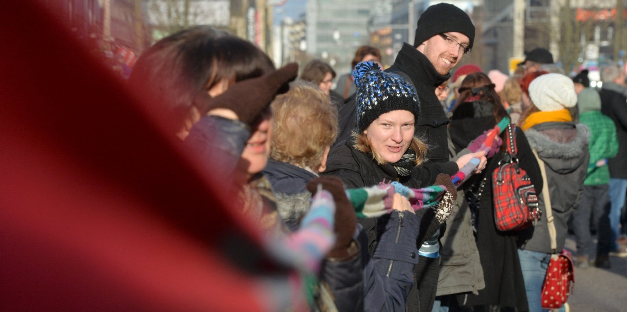Bürger und Gäste der Stadt Magdeburg beteiligen sich auf der "Meile der Demokratie" an einer Menschenkette entlang eines Schals, der über eine 1,6 Kilometer lang ist.