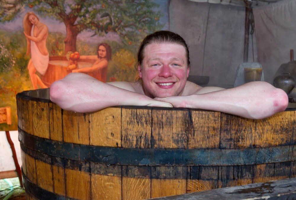 Patrick, der Bader, nimmt ein Bad in einem alten Schnapsfass.