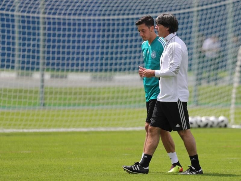 Joachim Löw (r) bei der WM in Russland im Gespräch mit Mesut Özil. Der Bundestrainer muss die Özils Position neu besetzen. Foto: Christian Charisius