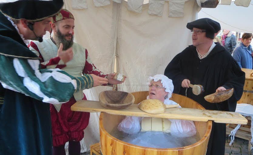 Bürgermeisterin Jutta Fischer sitzt im Zuber und Luther (r.) schwingt die Badebürste.
