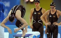Die deutsche Schwimmerin Meike Freitag taucht ins Wasser ein. Ihre Teamkolleginnen Antje Buschulte und Daniela Goetz warten im Hintergrund. (Foto: dpa)