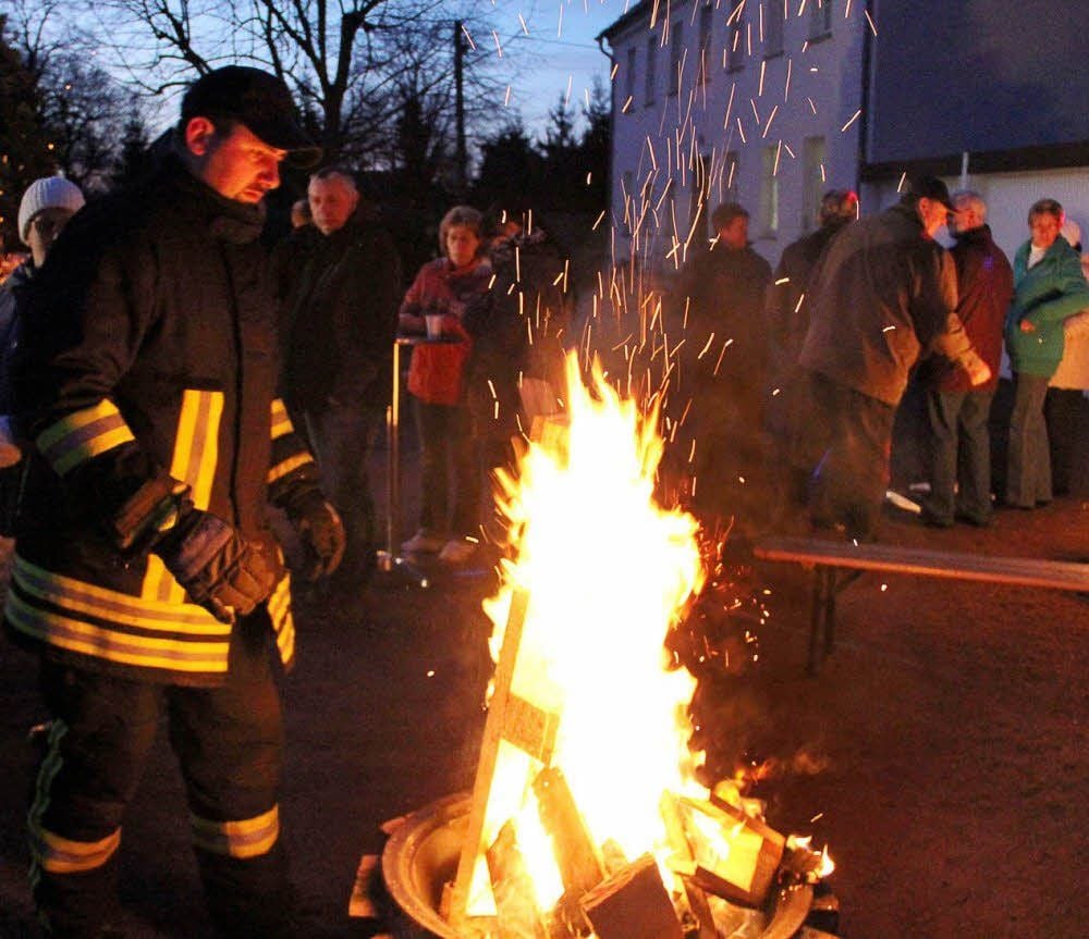 Feuerwehrmann Daniel Belitz legte immer wieder trockenes Holz nach, so dass das Feuer in den Feuerschalen nicht ausging. Um die Flammen herum hatten sich zahlreiche Neugattersleber versammelt.