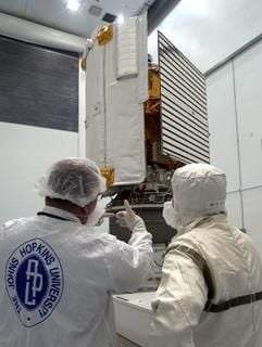 Die NASA-Raumsonde Messenger steht mit ihrem Sonnenschutzschild (l) und dem Solarpanel (r) auf einem Transporter in Titusville während Mitarbeiter der John Hopkins Universität an ihr arbeiten (Aufnahem vom 14.07.2004). Messenger soll 2011 in eine Umlaufbahn um den Merkur einschwenken. (Foto: dpa)