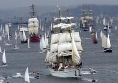 Unter Segel läuft am Samstag (26.06.2004) das Segelschulschiff «Gorch Fock» der deutschen Marine umringt von Begleitbooten an der Spitze der kilometerlangen Windjammerparade auf der Kieler Förde. Rund 100 Groß- und Traditionssegler beteiligen sich an dem maritimen Höhepunkt zum Abluss der Kieler Woche. Hinten rechts die russische Krusenstern zu sehen. (Foto: dpa)