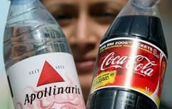 Eine junge Frau zeigt eine Coca-Cola- und eine Apollinaris-Flasche (l.). Der Getränkekonzern Coca-Cola kauft die traditionsreiche Mineralwassermarke Apollinaris. (Foto: dpa)