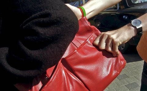 Ein Dieb raubt einer Frau die Handtasche.