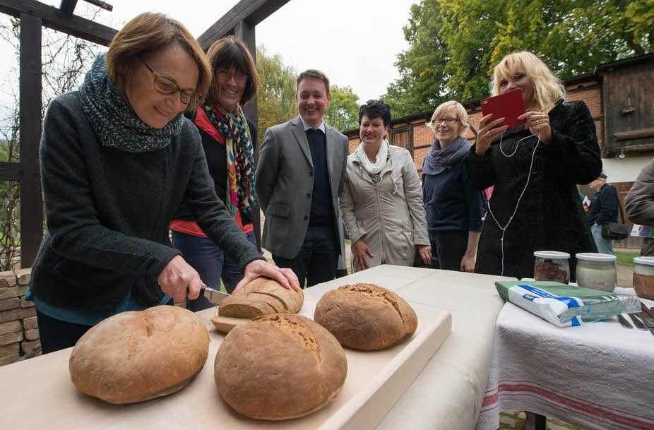 Antje Steinecker schneidet das frisch gebackene Brot aus dem Lehmbackofen an.