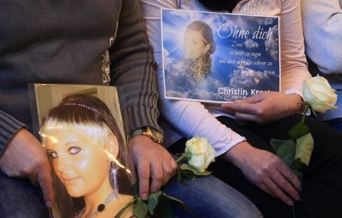 Angehörige halten Bilder einer getöteten Frau und Rosen am 06.02.2013 im Landgericht in Magdeburg (FOTO: DPA)
