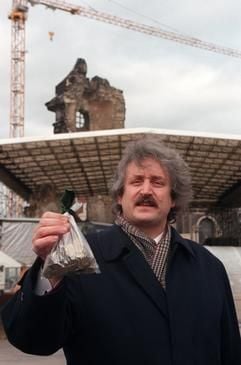 Der Vorsitzende der Gesellschaft zur Förderung des Wiederaufbaus der Frauenkirche Dresden e.V., der Startrompeter Ludwig Güttler, präsentiert vor der Ruine der Kirche einen Beutel mit Kleingeld, den er als Spende einer unbekannten Dresdnerin erhalten hat, Archivbild vom 11.02.1995. (Foto: dpa)