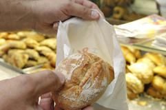 Bäcker Oliver Sporys packt in seinem Berliner Laden mehrere «Ostschrippen» für eine Kundin in eine Papiertüte. (Foto: dpa)