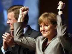 Neben dem niedersächsischen Ministerpräsidenten Christian Wulff bedankt sich die Kanzlerkandidatin und CDU-Vorsitzende Angela Merkel am Samstag (9. Juli 2005) auf dem niedersächsischen Landesparteitag in Emden für den Beifall nach ihrer Rede. (Foto: dpa)