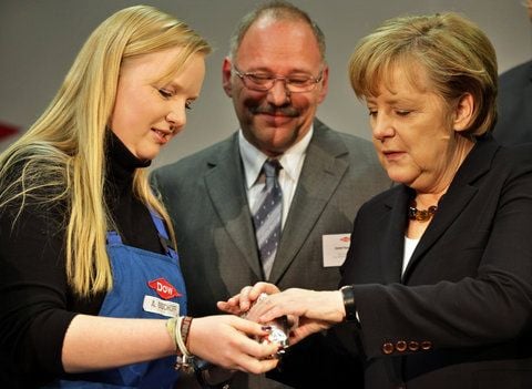 Die Dow-Mitarbeiterein Anja Bischoff (l) erläutert Bundeskanzlerin Angela Merkel (CDU) eine Tube mit Spezialklebstoff im Chemiewerk Schkopau der Dow Olefinverbund GmbH. (FOTO: DPA)