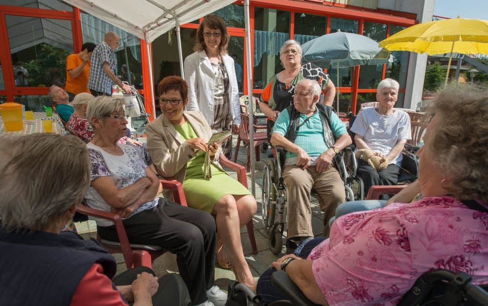 Heike Schittko (grünes Kleid) und Monika Reuschel informieren sich bei Sabine Mrosek (stehend, v. li.) über die Arbeit in der Seniorenpflege.