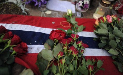 Rosen liegen gegenüber der Fjordinsel Utoya in Norwegen auf einer norwegischen Flagge. (FOTO: DPA)