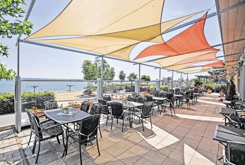 Krasser können die Sichten nicht sein: Der Sandsackwall passt so gar nicht in die Idylle unterm Sonnensegel des Restaurants „Seaview“. Die Bilder sind quasi zwei Seiten einer Medaille.