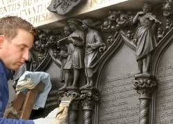 Der Küster Ivo Behr säubert an der Schlosskirche in Wittenberg die Bronzegusstür des Eingangsportals mit dem Text der 95 Thesen des Reformatos Martin Luther und darüber angebrachten singenden Kindern für die Feierlichkeiten zum Reformationsfest. Die zwei aus Bronze gegossenen Flügeltüren, die die während der Befreiungskriege zerstörte alte Thesentür ersetzen, wurden nach einem Entwurf des preußischen Konservators der Kunstdenkmäler, Ferdinand von Quast, angefertigt und 1858 eingeweiht. In Wittenberg wird am 31. Oktober 2002 das Reformationsfest mit einem Festgottesdienst und Marktspektakel begangen. Der Reformator Martin Luther (1483-1546) soll nach wissenschaftlich nicht bestätigten Überlieferungen am 31. Oktober 1517 seine 95 Thesen zur Kritik, vor allem am Ablasshandel der katholischen Kirche, an die damals vorhandene Holztür der Schlosskirche geschlagen haben)