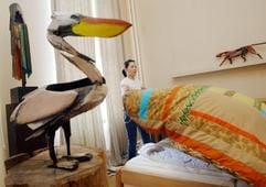 Ein Zimmermädchen schüttelt das Bett im "Safari-Zimmer" des Berliner Künstlers Dieter Finke im Hotel "Künstlerheim Luise" in Berlins Mitte auf (Foto vom 27.09.02). Das Konzept, ein Hotel mit Kunst zu gestalten, hat sich inzwischen durchgesetzt. Im Hotel Künstlerheim Luise haben die Künstler besonders viel Einfluss: Jeder gestaltet ein Zimmer in völliger Eigenregie und erhaelt fünf Prozent des Raum-Erlöses. "Einzige Bedingung ist eine gastliche Atmosphäre", sagt der Galerist Christian Bree. (Foto: ddp)