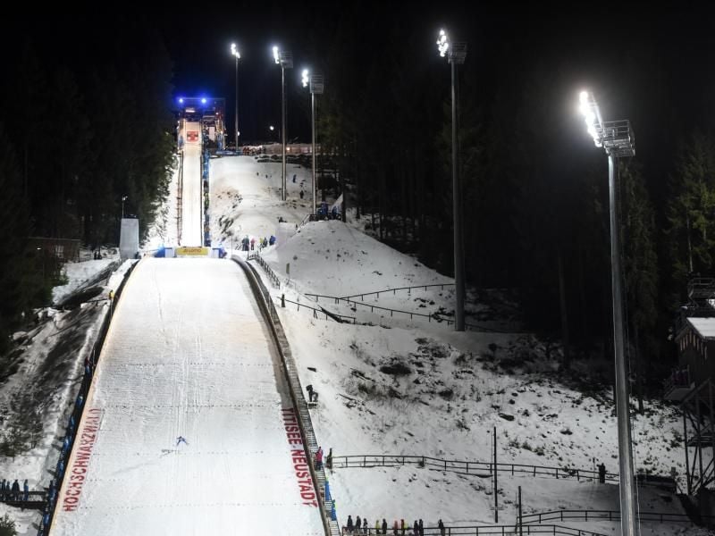 Unter der Flutlichtanlage springt ein Springer durch die Luft. Foto: picture alliance / Patrick Seeger/dpa