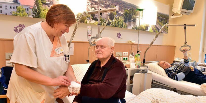 Stationsleiterin Michaela Otto schaut nach Olaf Bauers Hand.