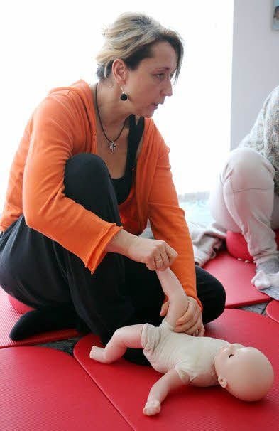 Hebamme Klaudia Schulze zeigt an der Puppe, wie es geht.