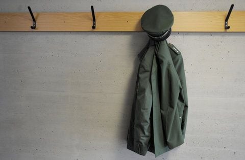 Eine Polizeiuniform hängt an einem Kleiderhaken.