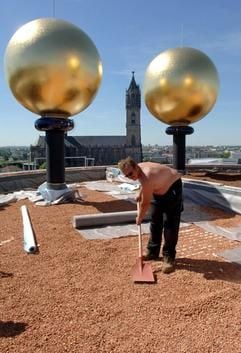 Ein Arbeiter bereitet am 23.06.2005 auf dem Dach des Hundertwasserhaus in Magdeburg den Boden für die Begrünung vor, im Hintergrund der Magdeburger Dom. Die «Grüne Zitadelle» ist das letzte große Bauprojekt des österreichischen Künstlers Friedensreich Hundertwasser (1928 bis 2000). (Foto: dpa)